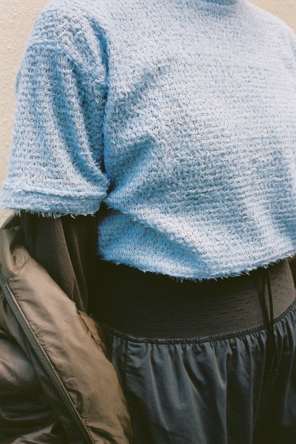 Shag Tee v2.0 in blue worn under a jacket, showcasing its lightweight and shaggy texture for active insulation.