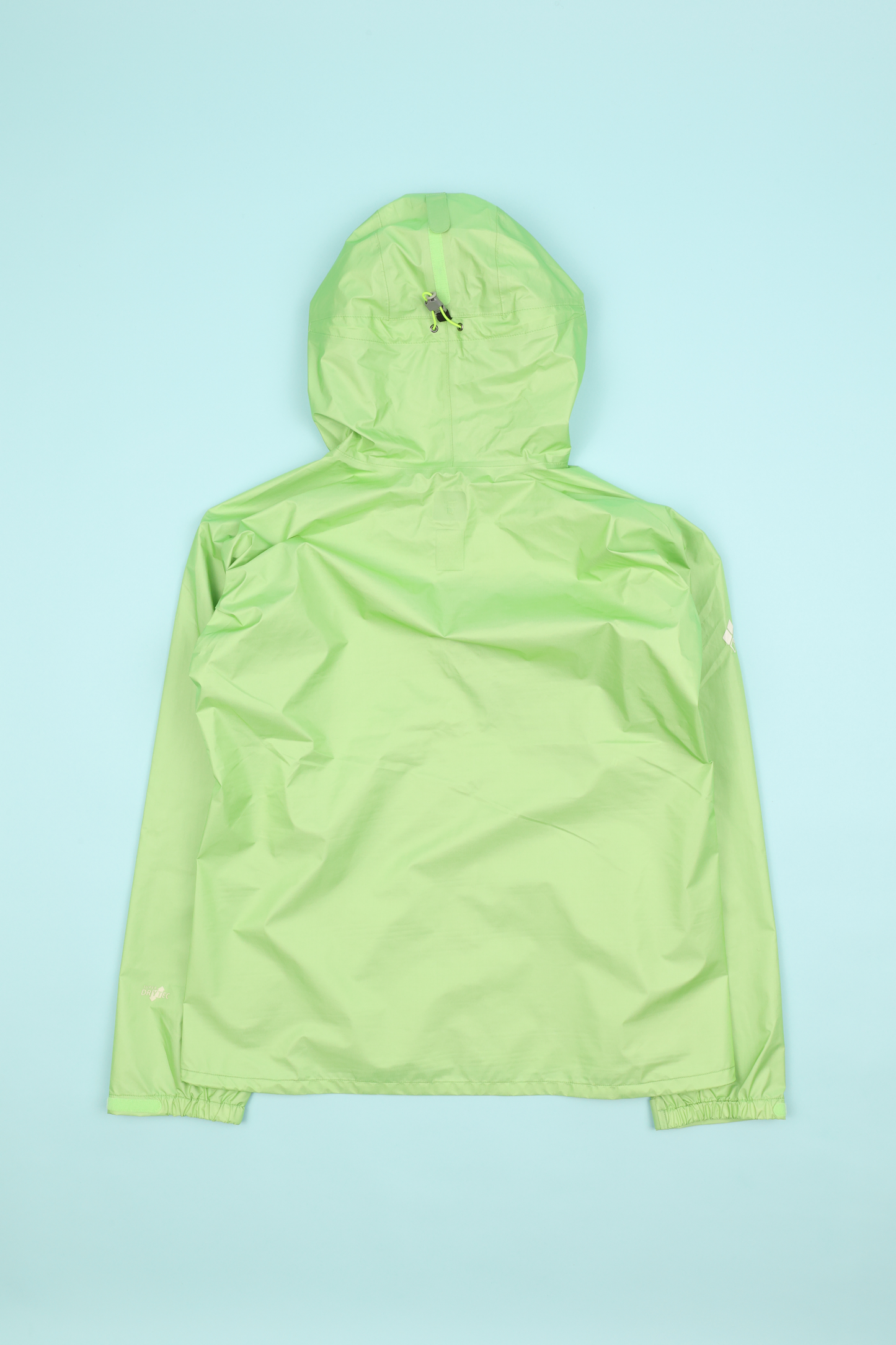 Montbell Womens Versalite Jacket - Light Green shown from the back on a light blue background.