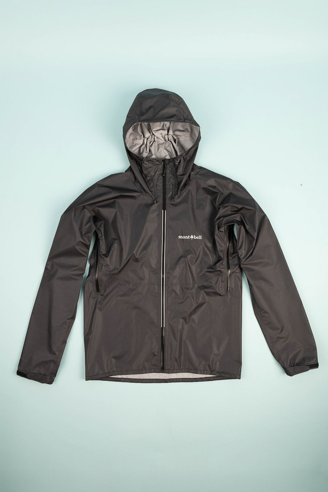 US Men's Versalite Jacket in black, featuring lightweight material and a hood for ultimate protection against rain.