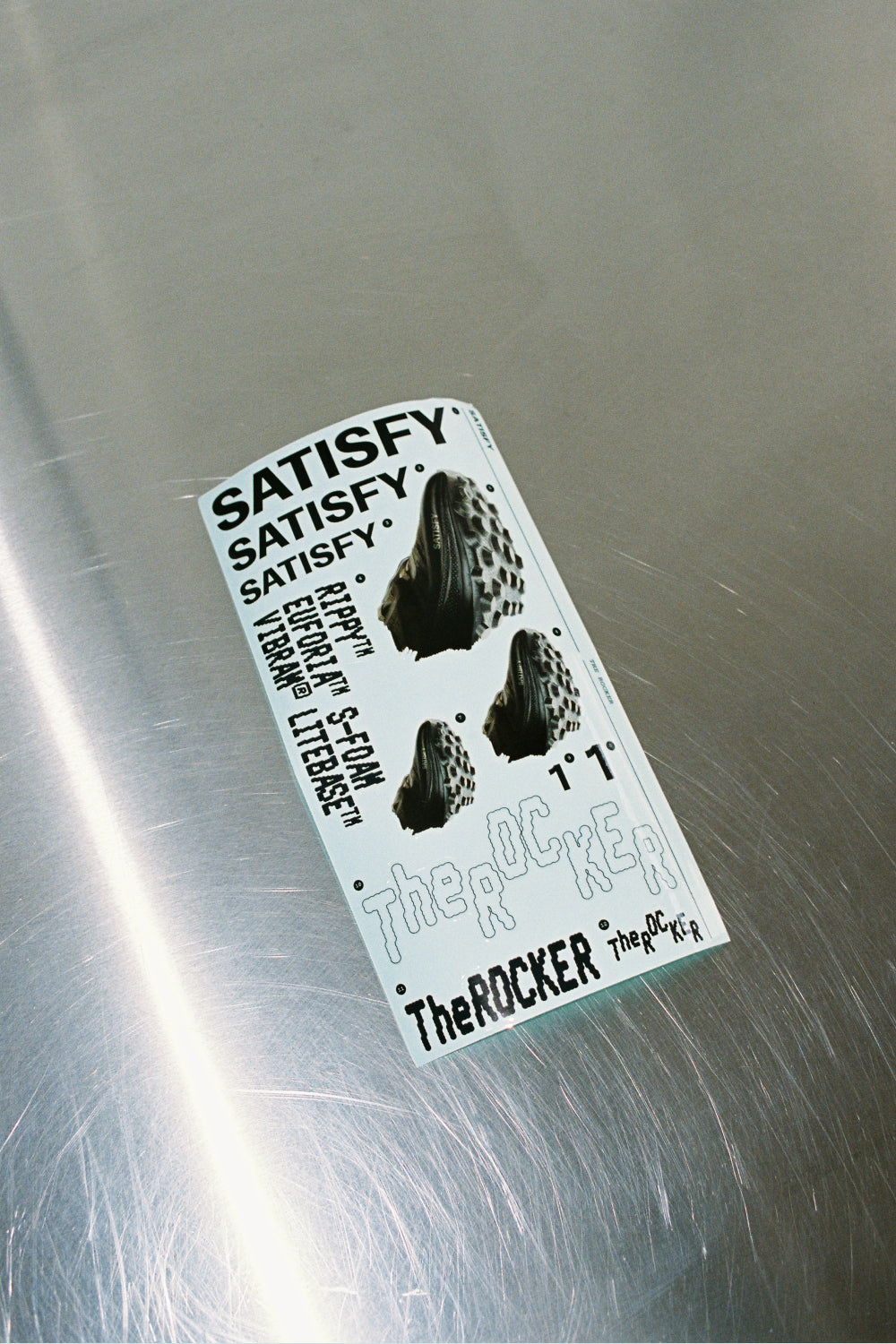 Satisfy TheROCKER - Antique White product label on metal surface showcasing performance features.