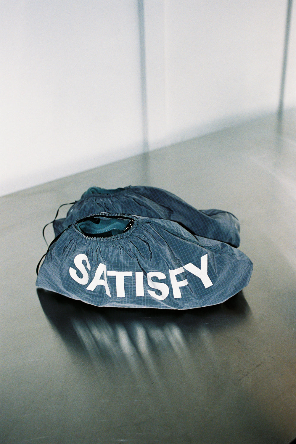 Satisfy TheROCKER - Shadow shoe model shown on a reflective surface with 'SATISFY' branding.