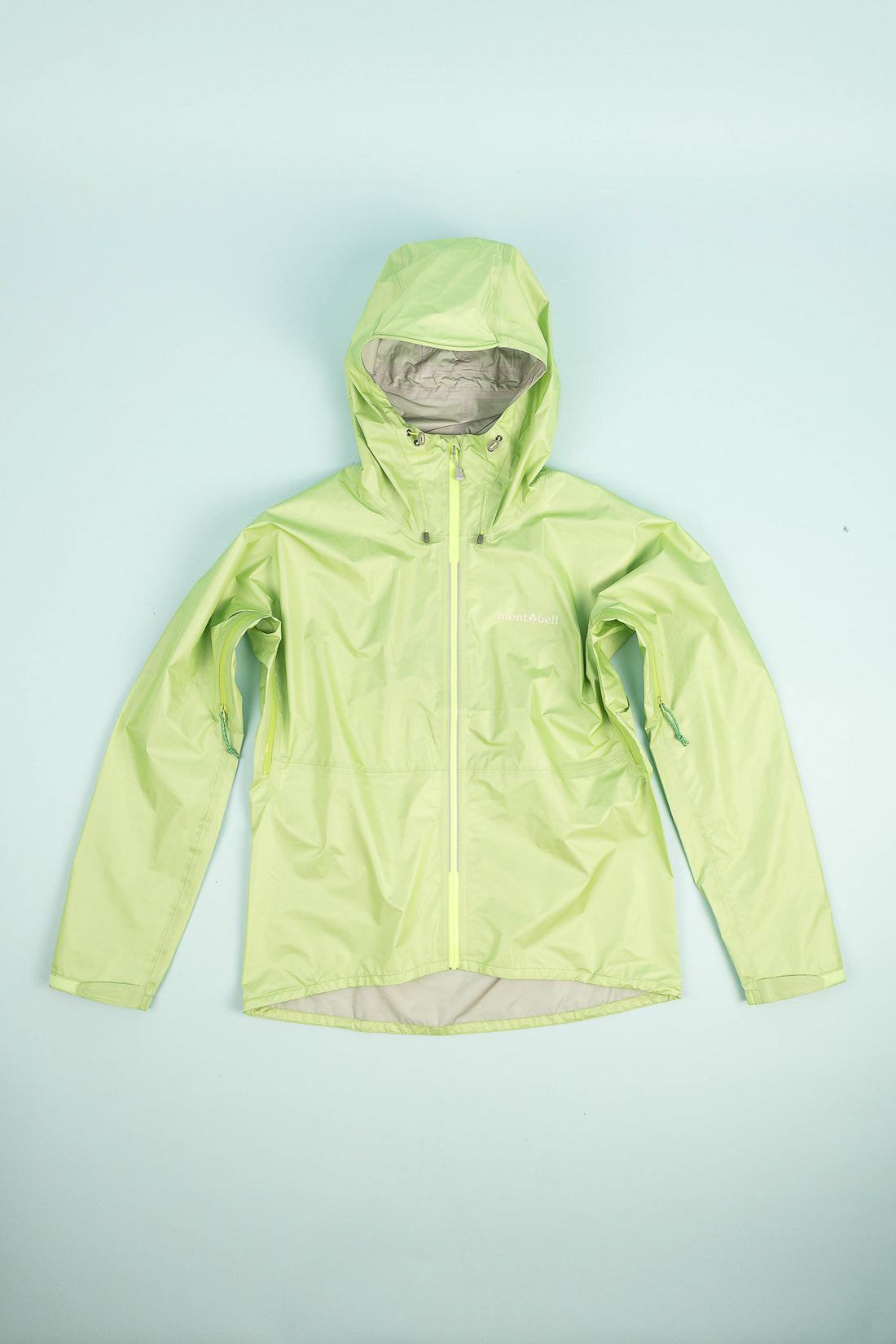 US Women's Versalite Jacket in light green color, showcasing its ultralight rain shell design.