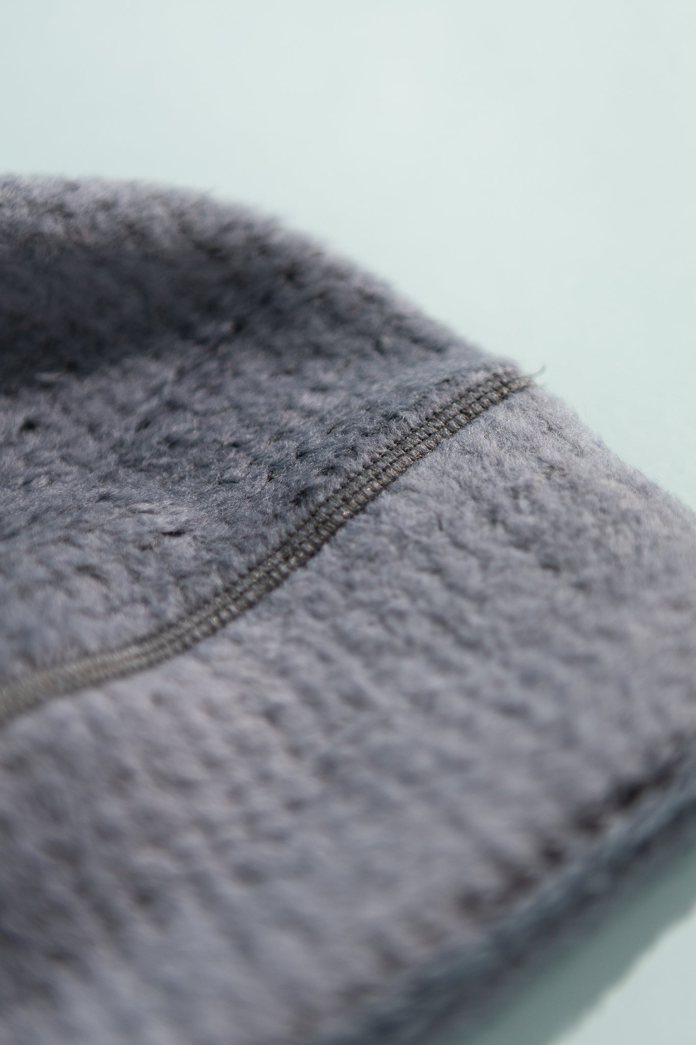 Close-up of the High Loft Wool Beanie showing soft grey fabric texture and stitching detail.