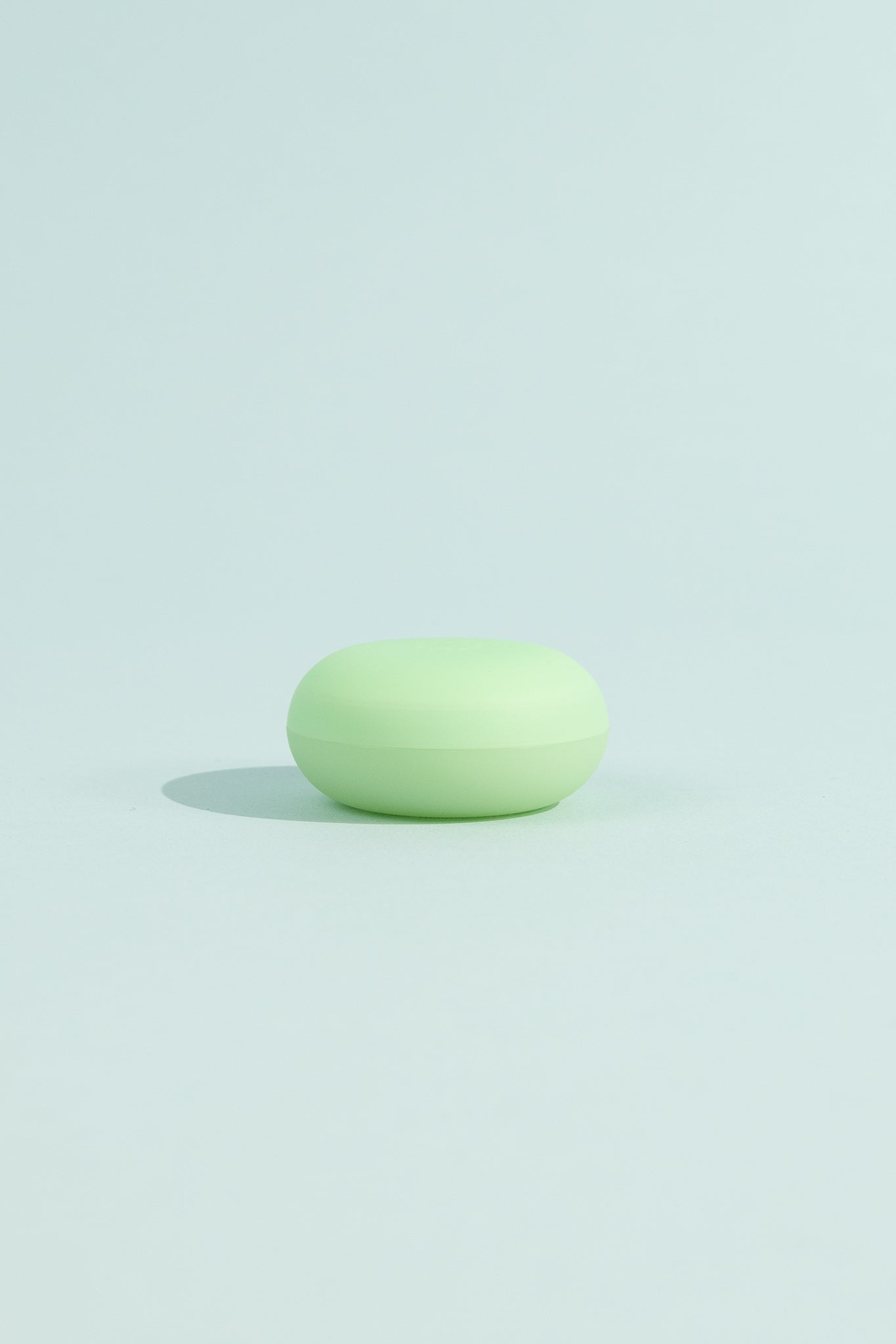 OEM Nourishing Lip Balm - Menthol in a green container on a light blue background.
