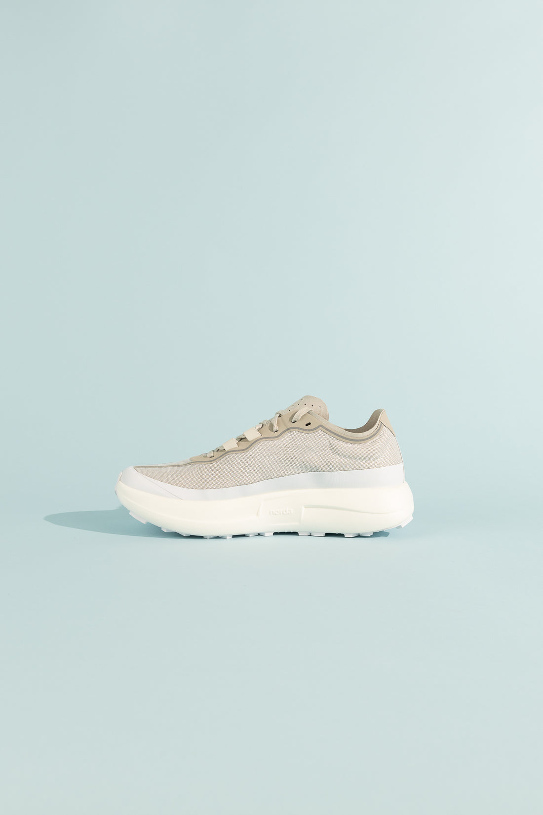 Side view of 005 - Névé trail shoe designed for stability and speed on flat terrains.