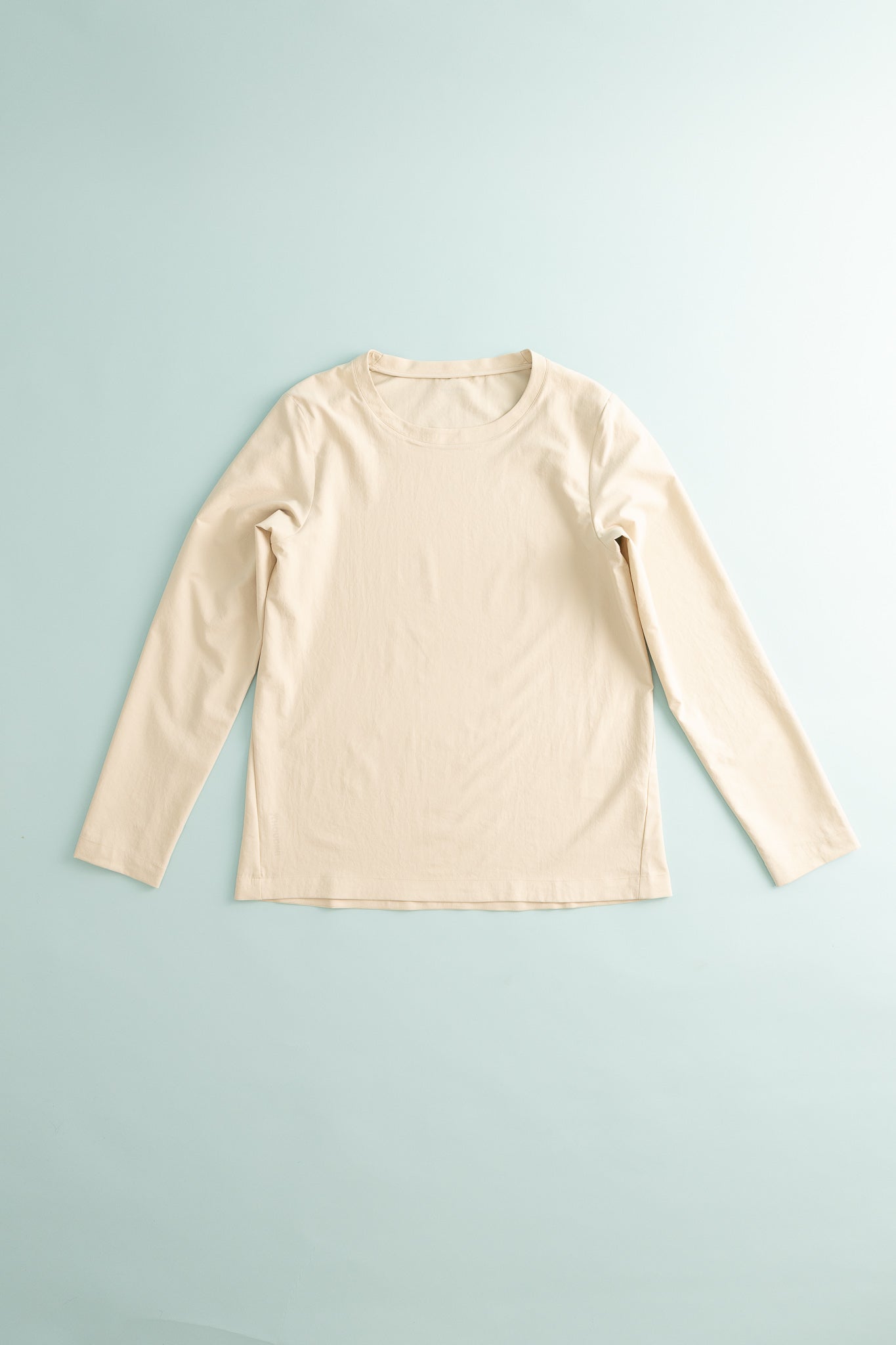 Womens Cover Crew Top in a light beige color, made from recycled soft stretchy fabric for sun protection.