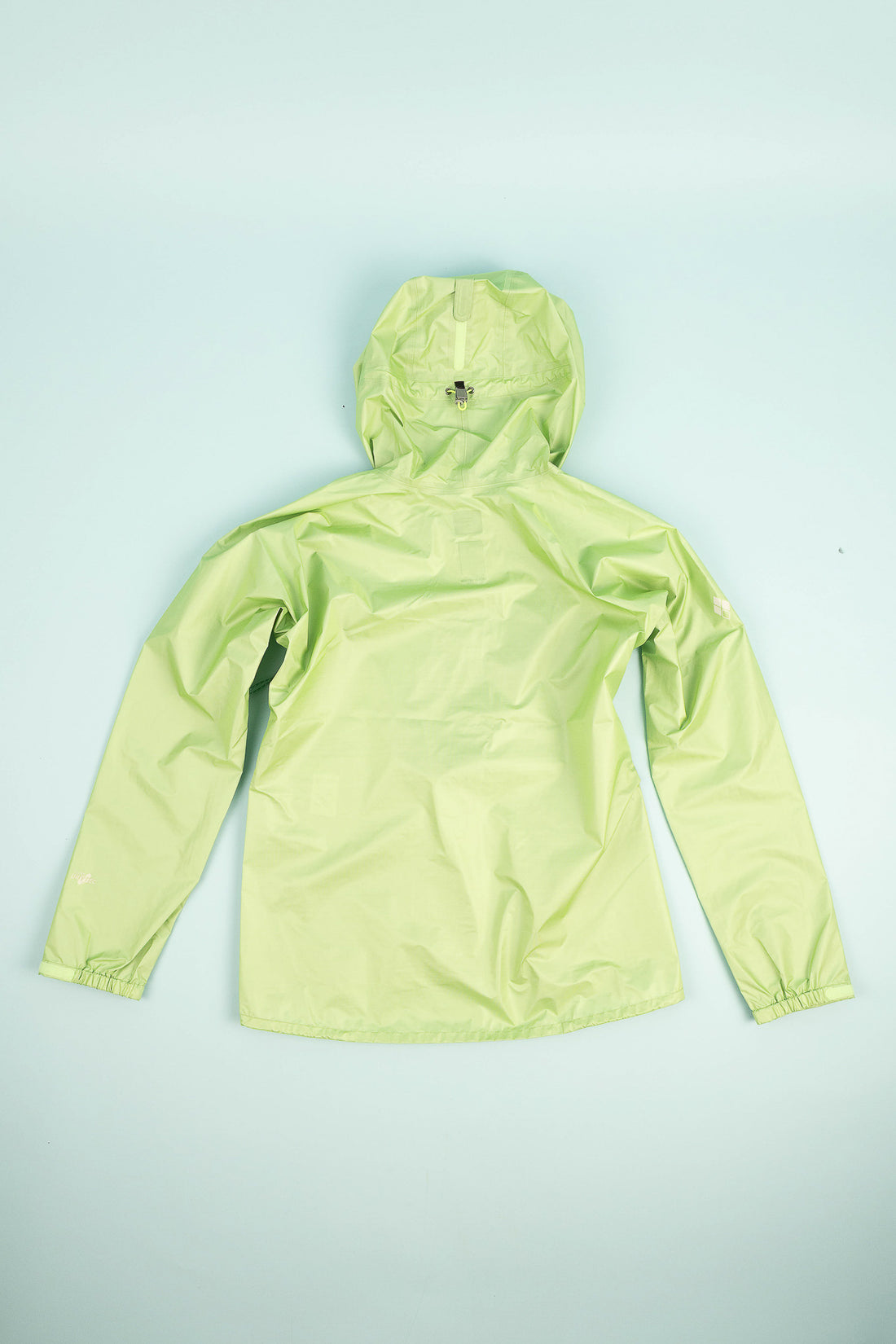 US Women's Versalite Jacket in light green, showcasing a lightweight rain shell with a hood.