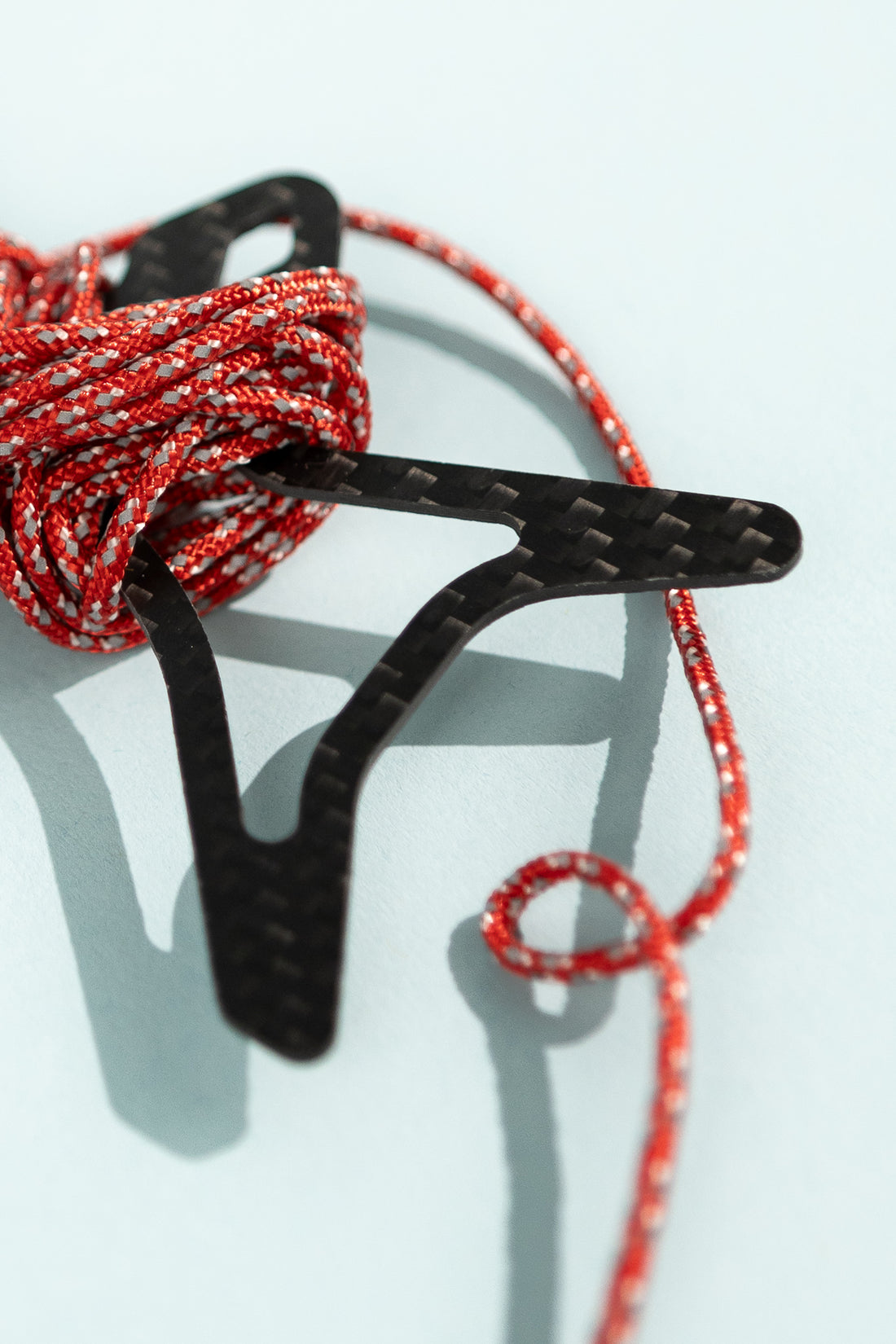 Close-up of a Carbon Cord Spool with red and black paracord coiled neatly.