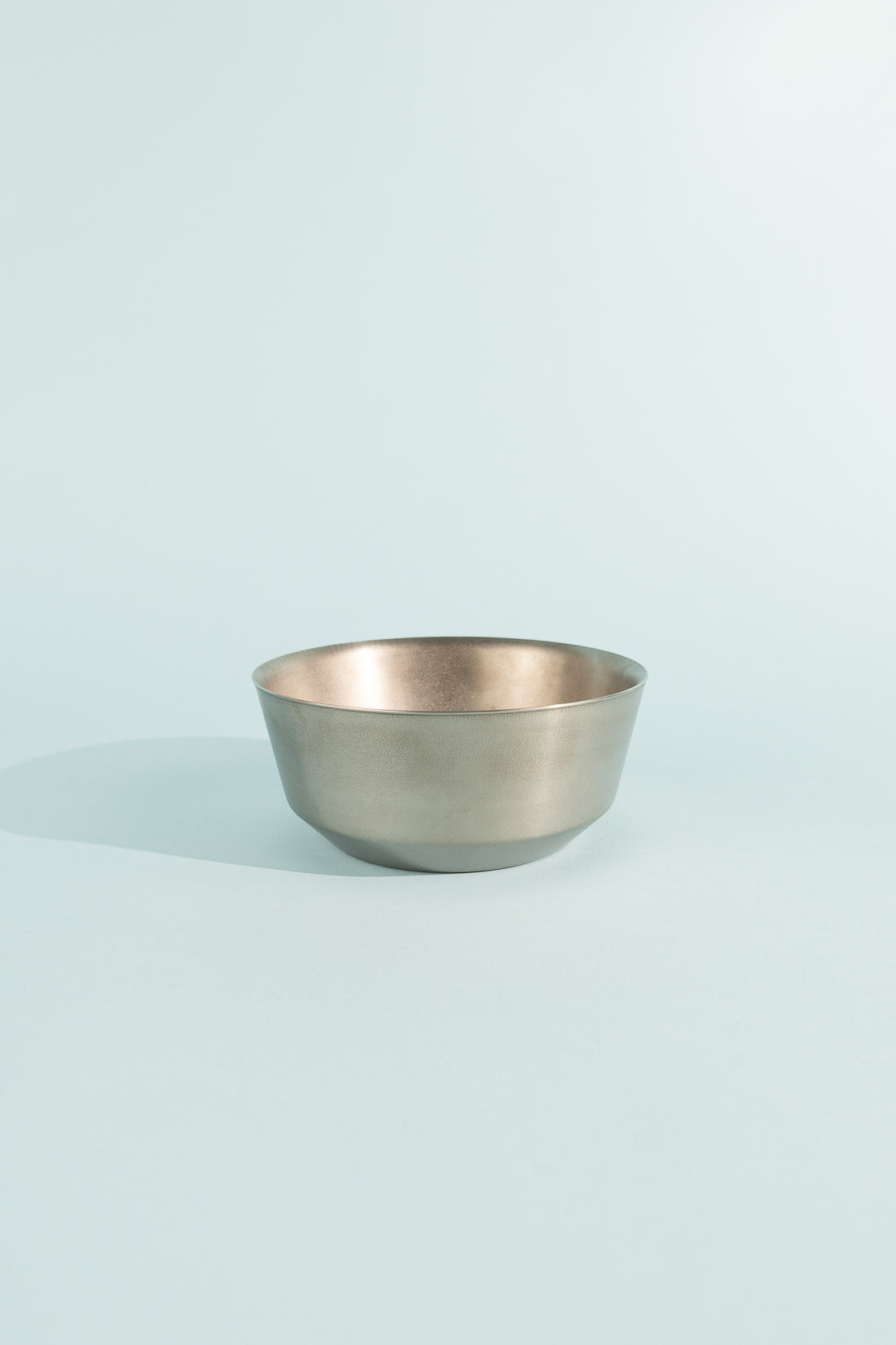 Titanium Double Wall Bowl on a light blue background, showcasing its sleek design and double-walled structure.