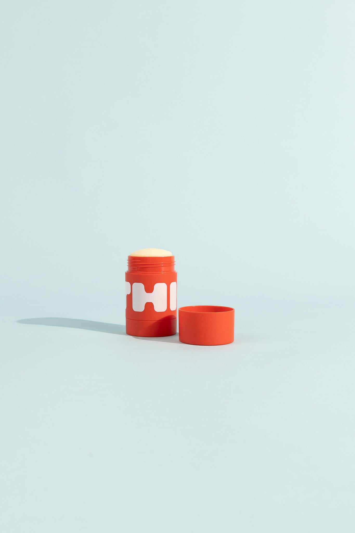 Stick Chafe Balm in a bright red container with a lid, designed to reduce friction and chafing.