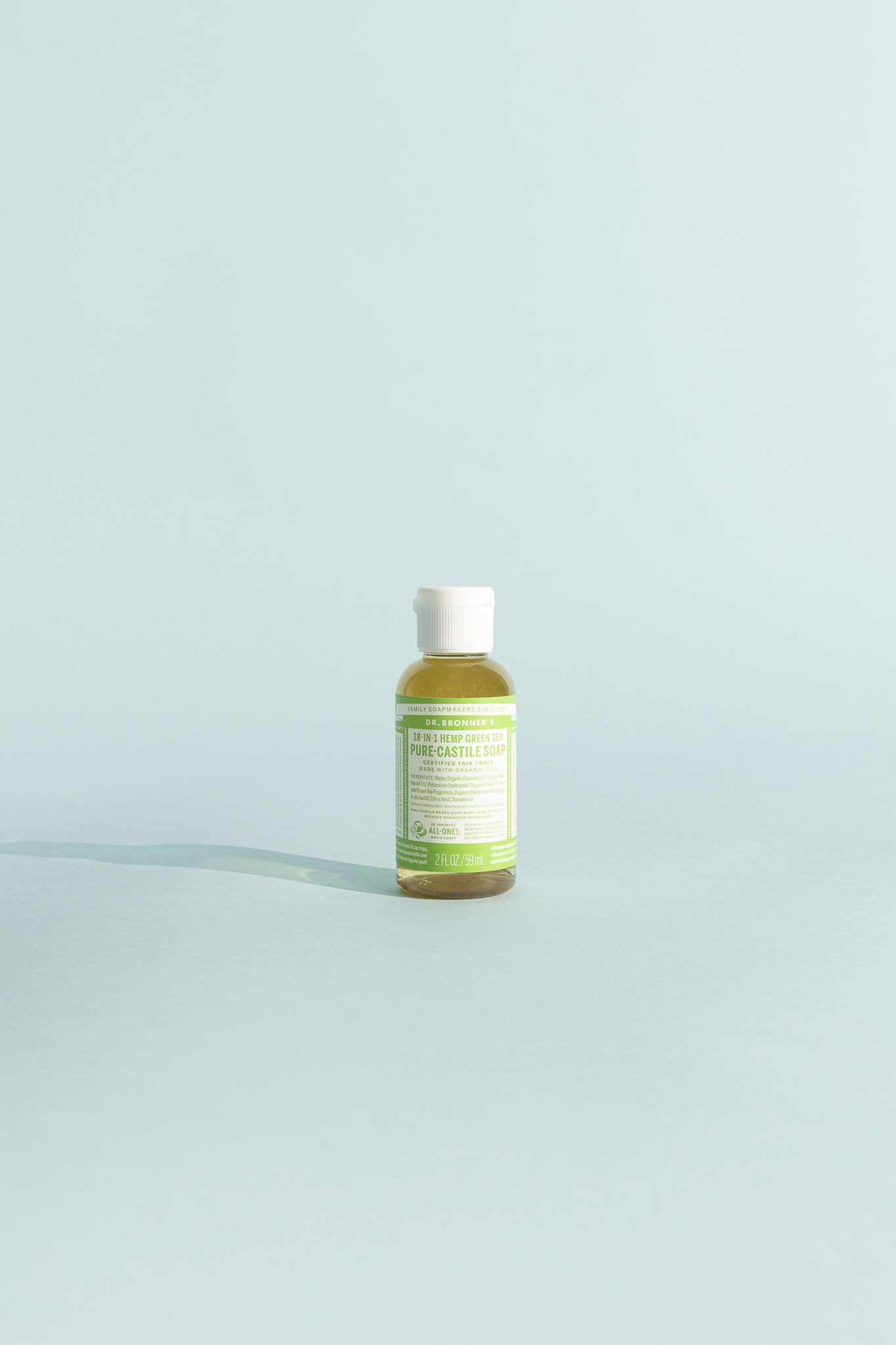 Green Tea Pure-Castile Liquid Soap - 59ml bottle on a soft blue background.