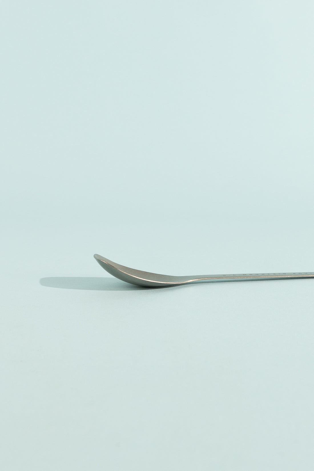 Evernew SputuraTi spoon lying flat on a pale background, showcasing its sleek design.
