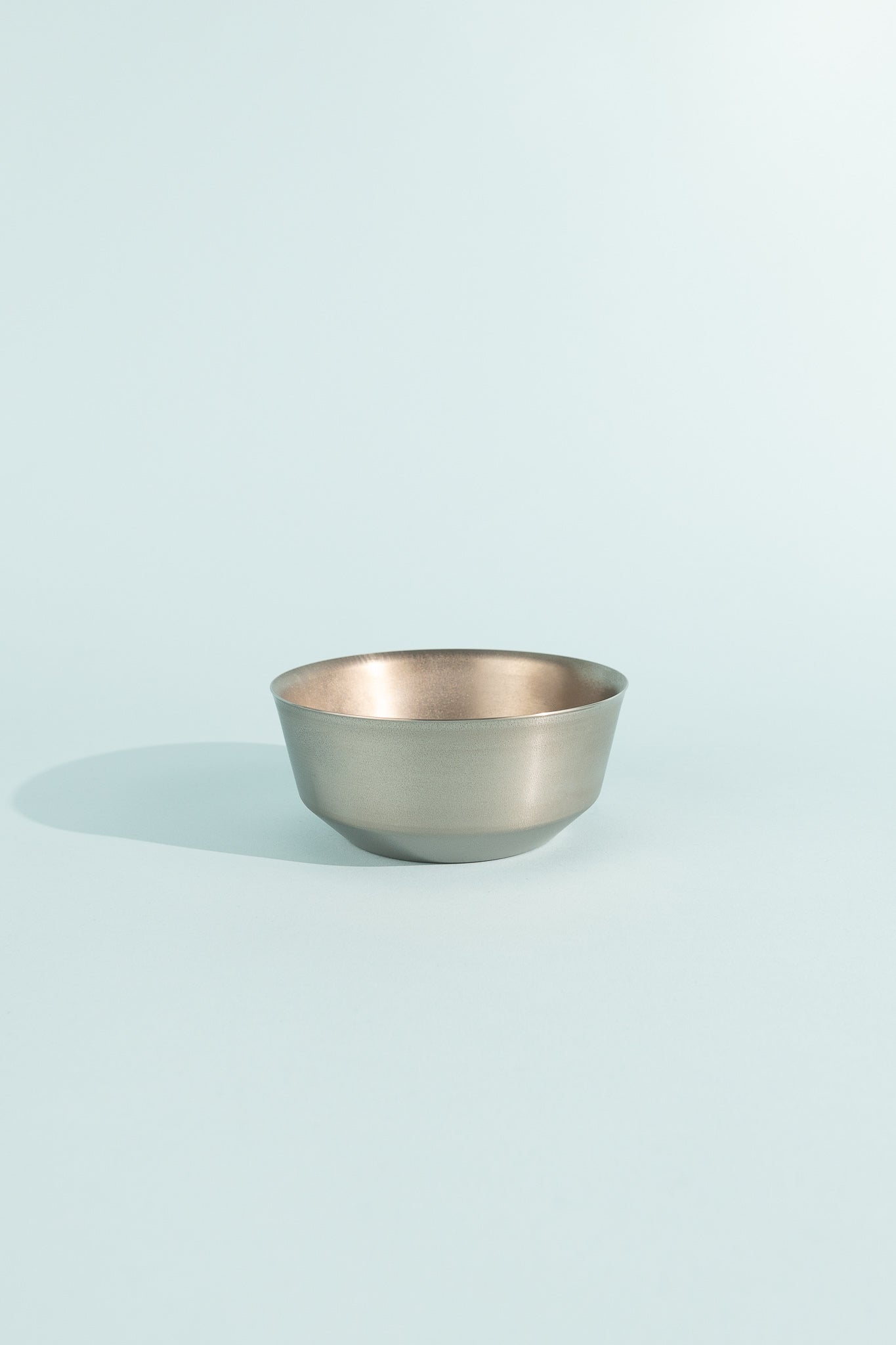 Titanium Double Wall Bowl 600 displayed against a light blue background, showcasing its sleek design.