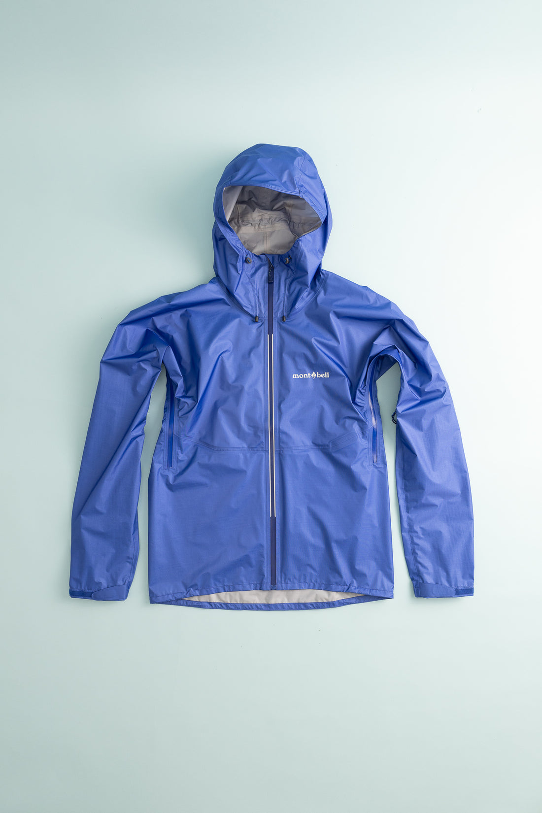 US Men's Versalite Jacket in blue color displayed on a light background, showcasing its ultralight and breathable design.