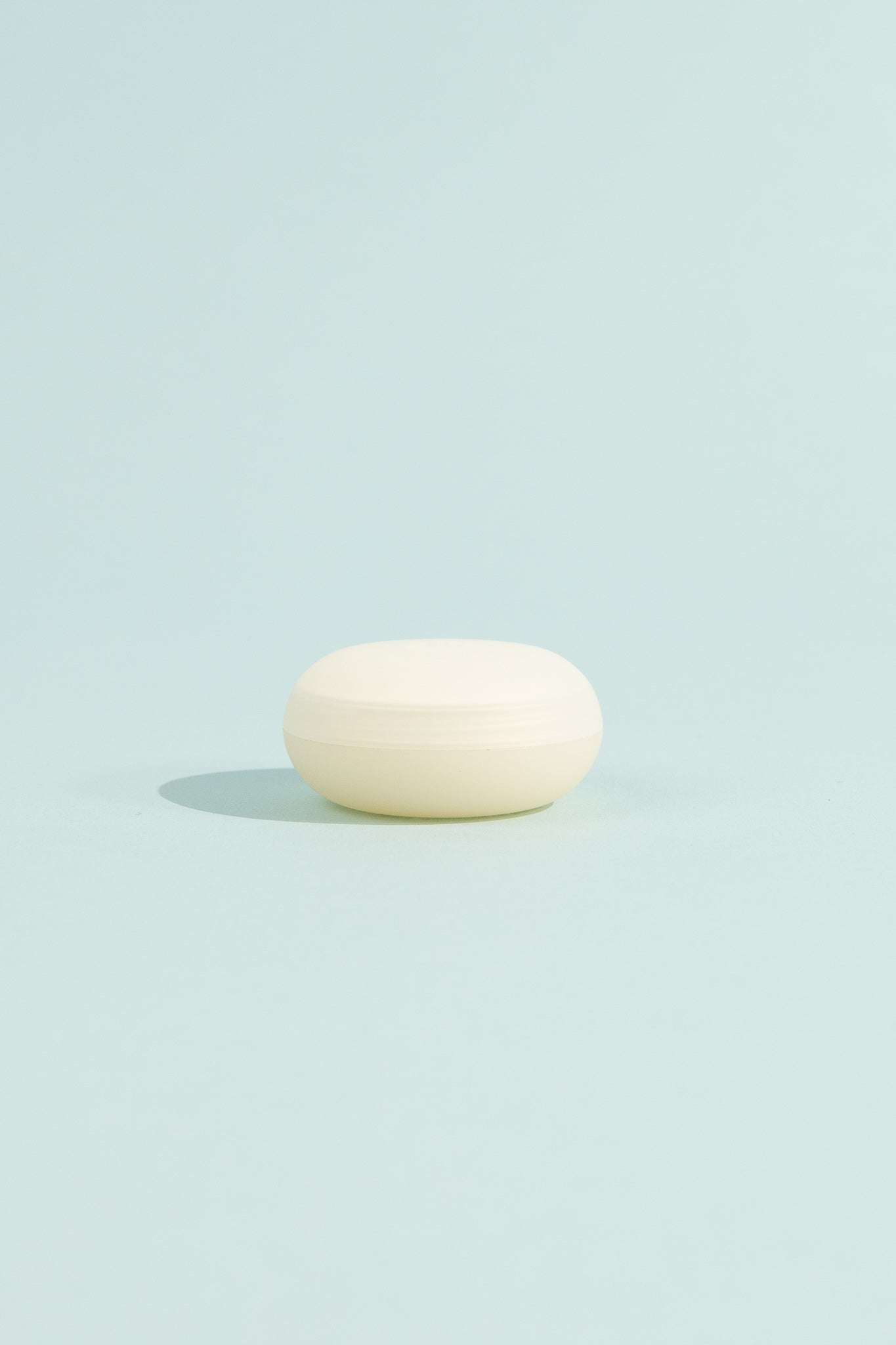 OEM Nourishing Lip Balm - Fragrance Free in a round container against a light blue background.