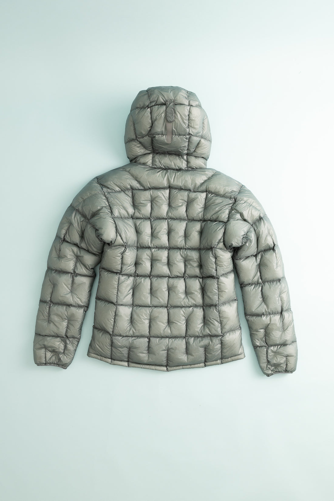 Back view of US Men's Plasma down parka in light gray with quilted design and hood.
