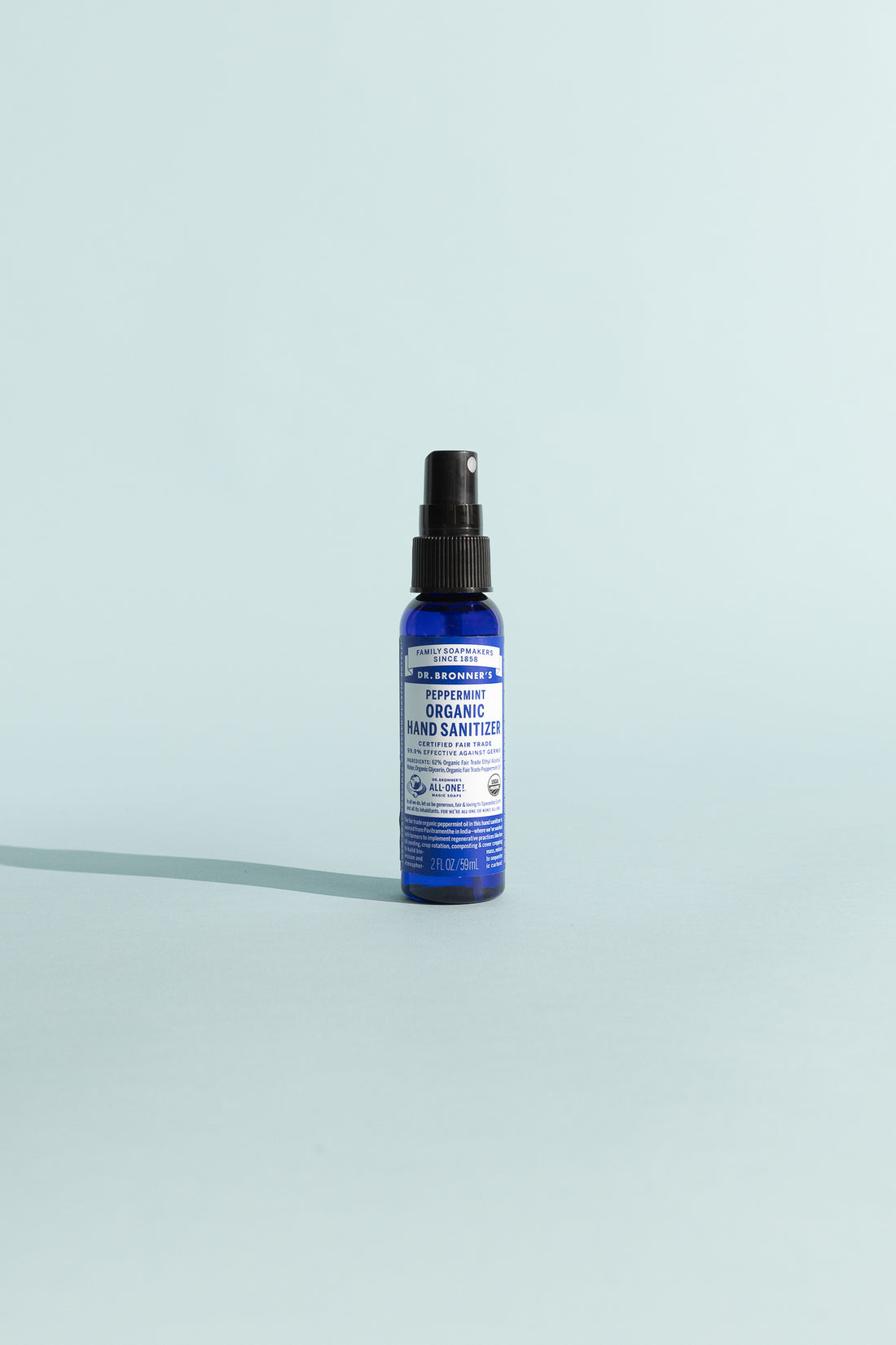 Peppermint Organic Hand Sanitiser in a spray bottle against a light blue background.