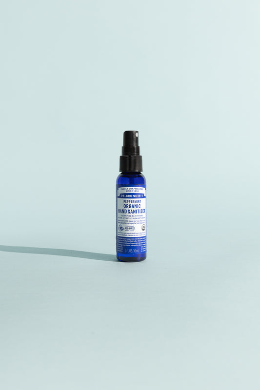 Peppermint Organic Hand Sanitiser in a spray bottle against a light blue background.