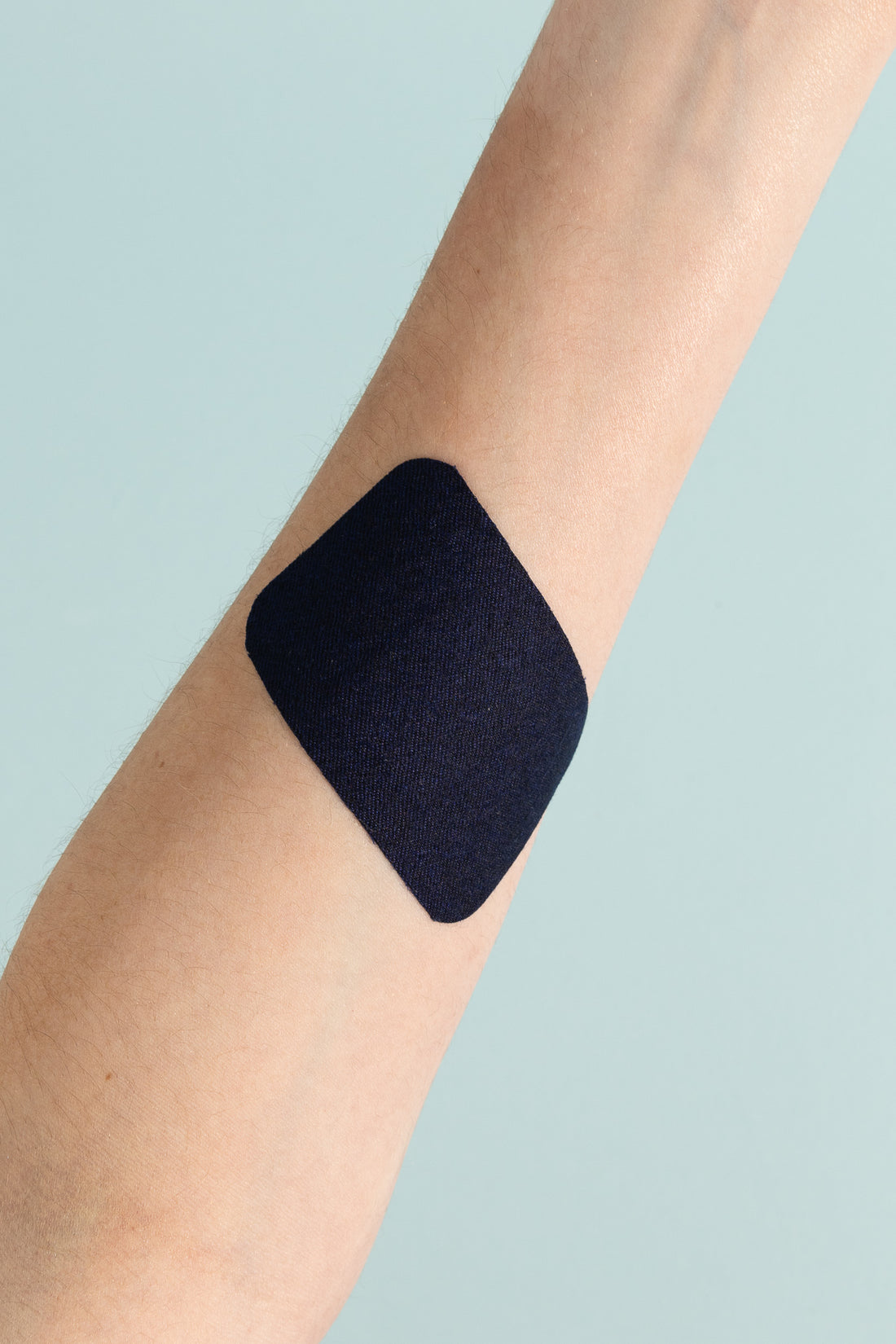 Merino Wool Adhesive Bandages on a person's arm for natural skin protection.