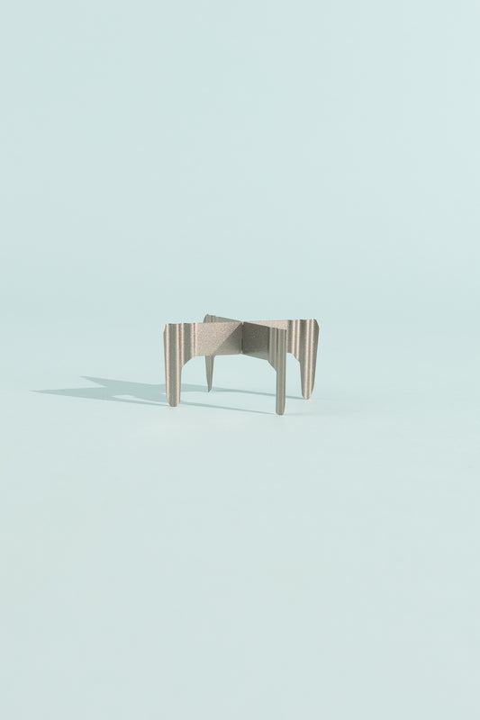 Evernew T0.3 TriveTi modern design table with unique striped legs on a light blue background.