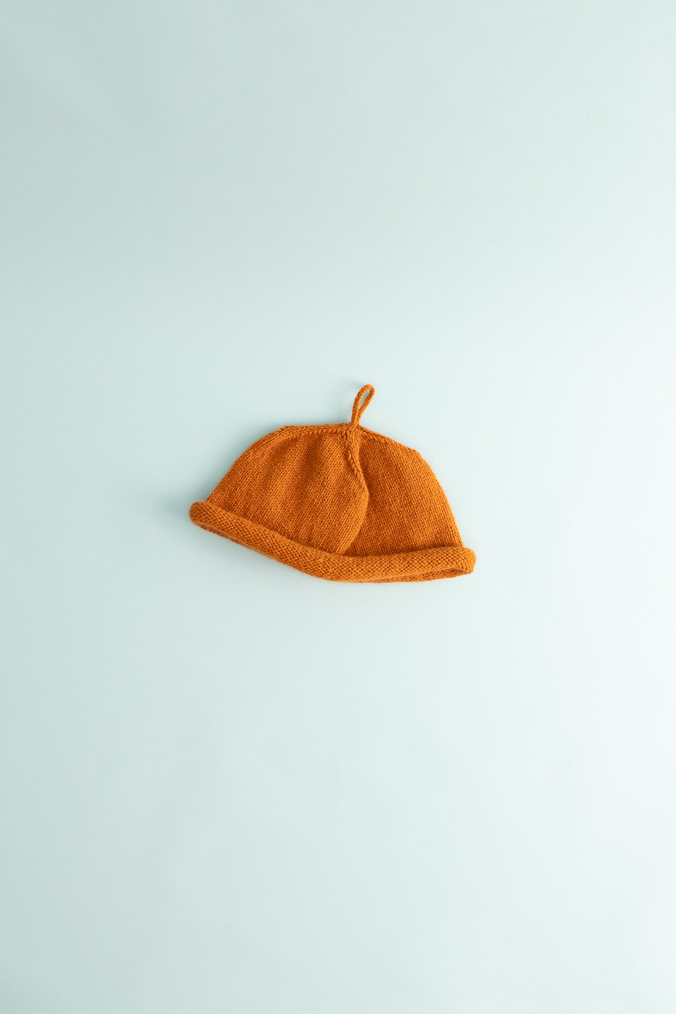 Bonnie Wroe Loop Hat - Orange on a light background, showcasing the soft possum merino yarn and unique design.