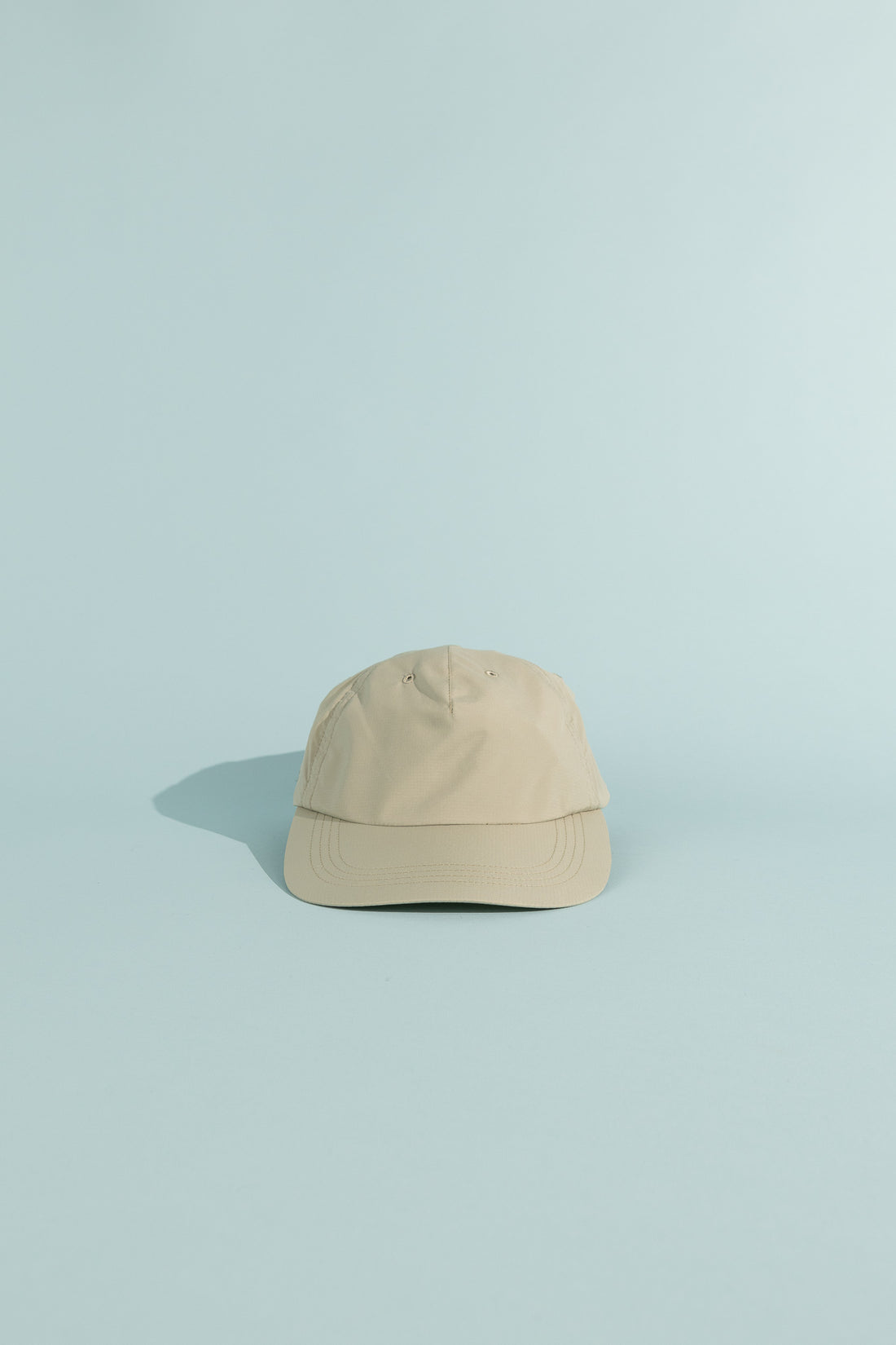 C9 Cap in greenish gray color on a light blue background, ideal for outdoor activities and sports.