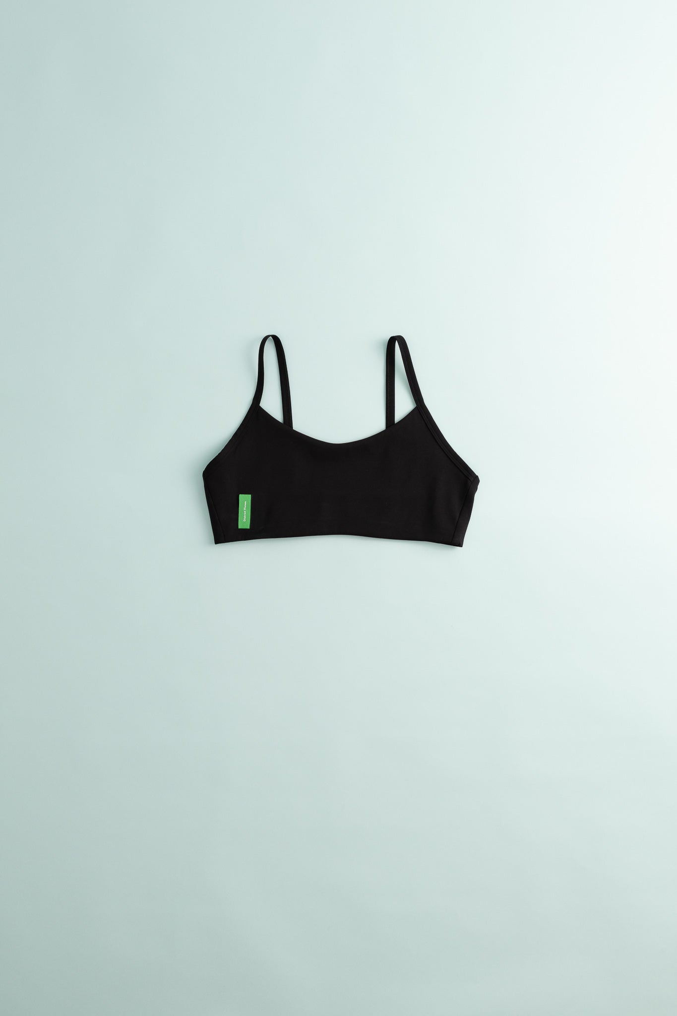 District Vision Womens Light Support Interlock Bra in black on a light background.