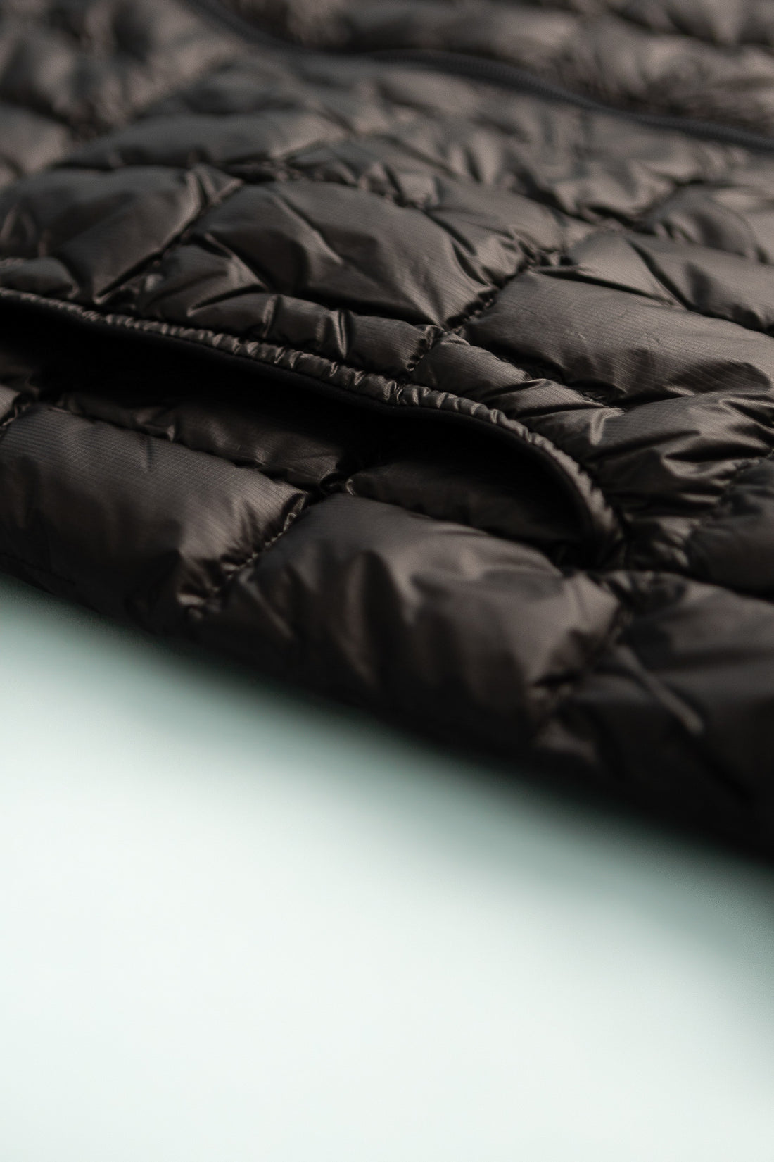US Men's Plasma 1000 Down Jacket detail showing lightweight black fabric and quilted design.