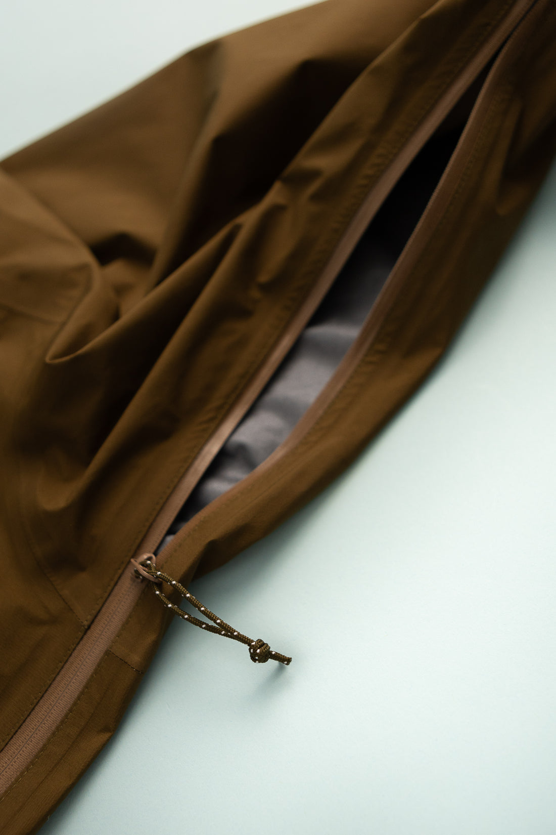 US Men's Tempest Jacket - Khaki close-up of jacket zipper detail.