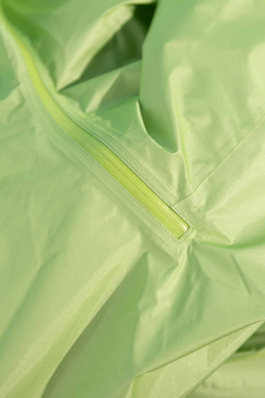 Close-up of the US Women's Versalite Jacket in light green showcasing the zipper and fabric detail.