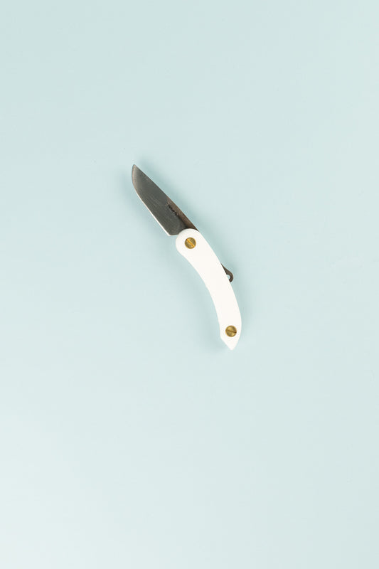 Peasant Knife Mini in white with a steel blade, handcrafted in New Zealand, featured against a light blue background.