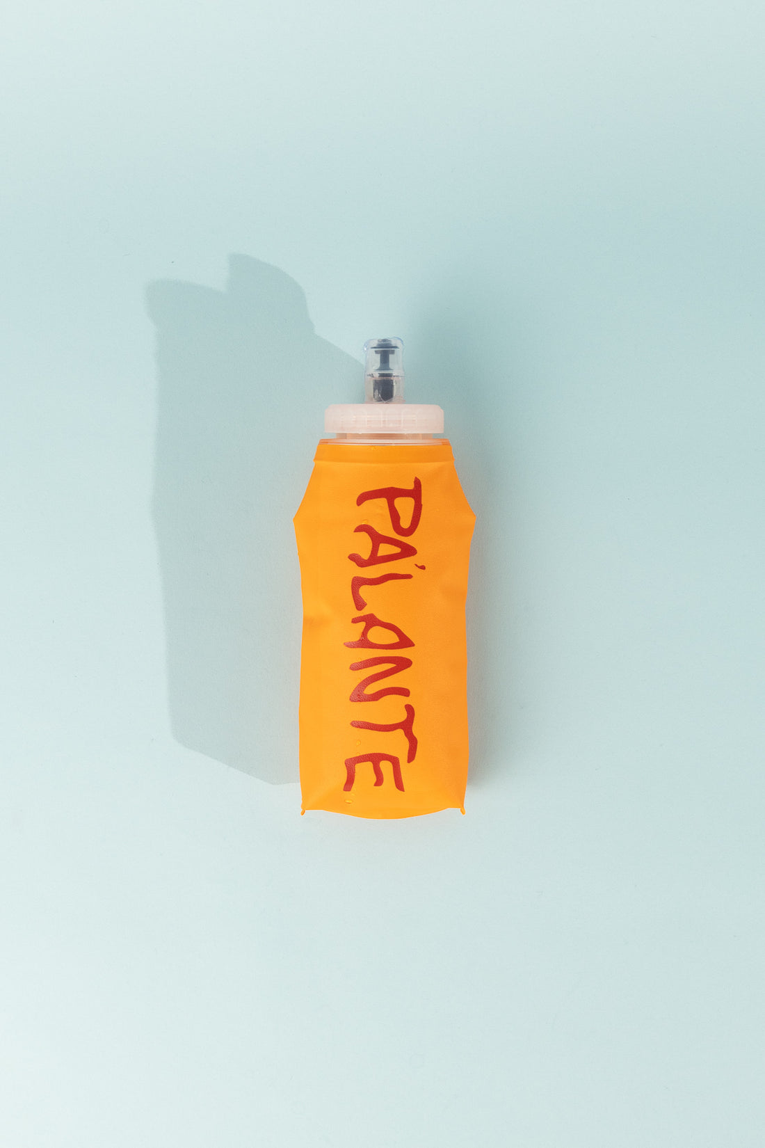 Floppy Water Bottle in bright orange featuring the word PALANTE, showcasing its collapsible design.