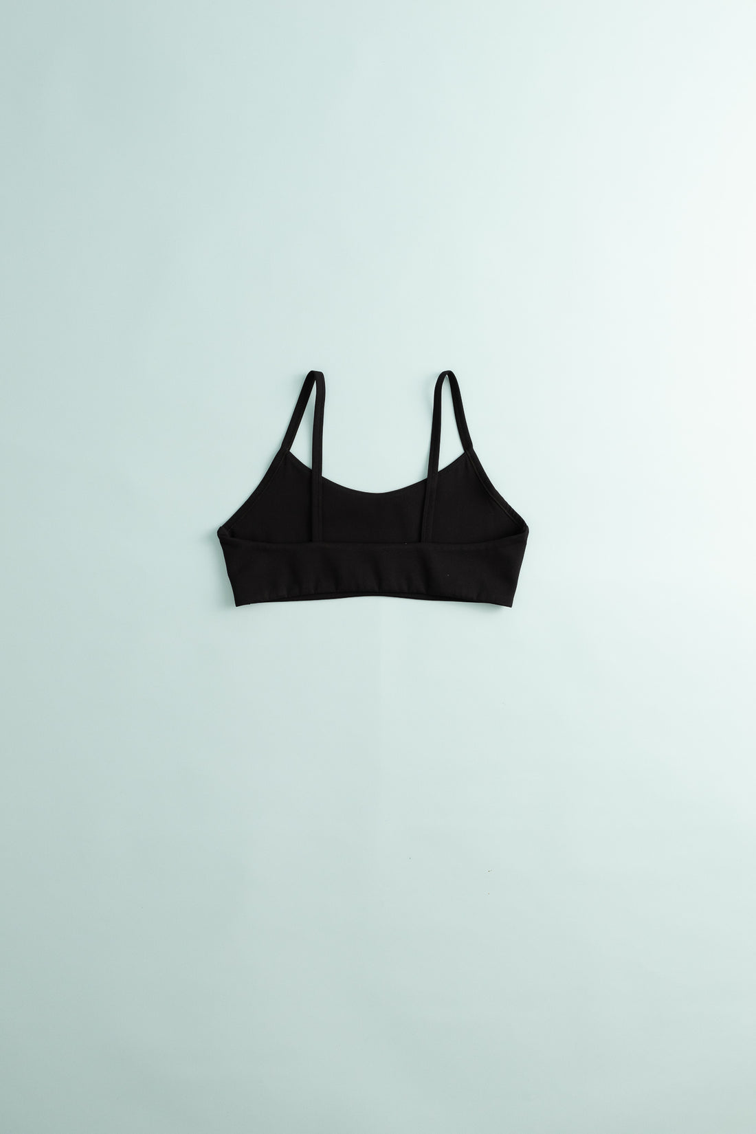 District Vision Women's Light Support Interlock Bra in black color on a light background.
