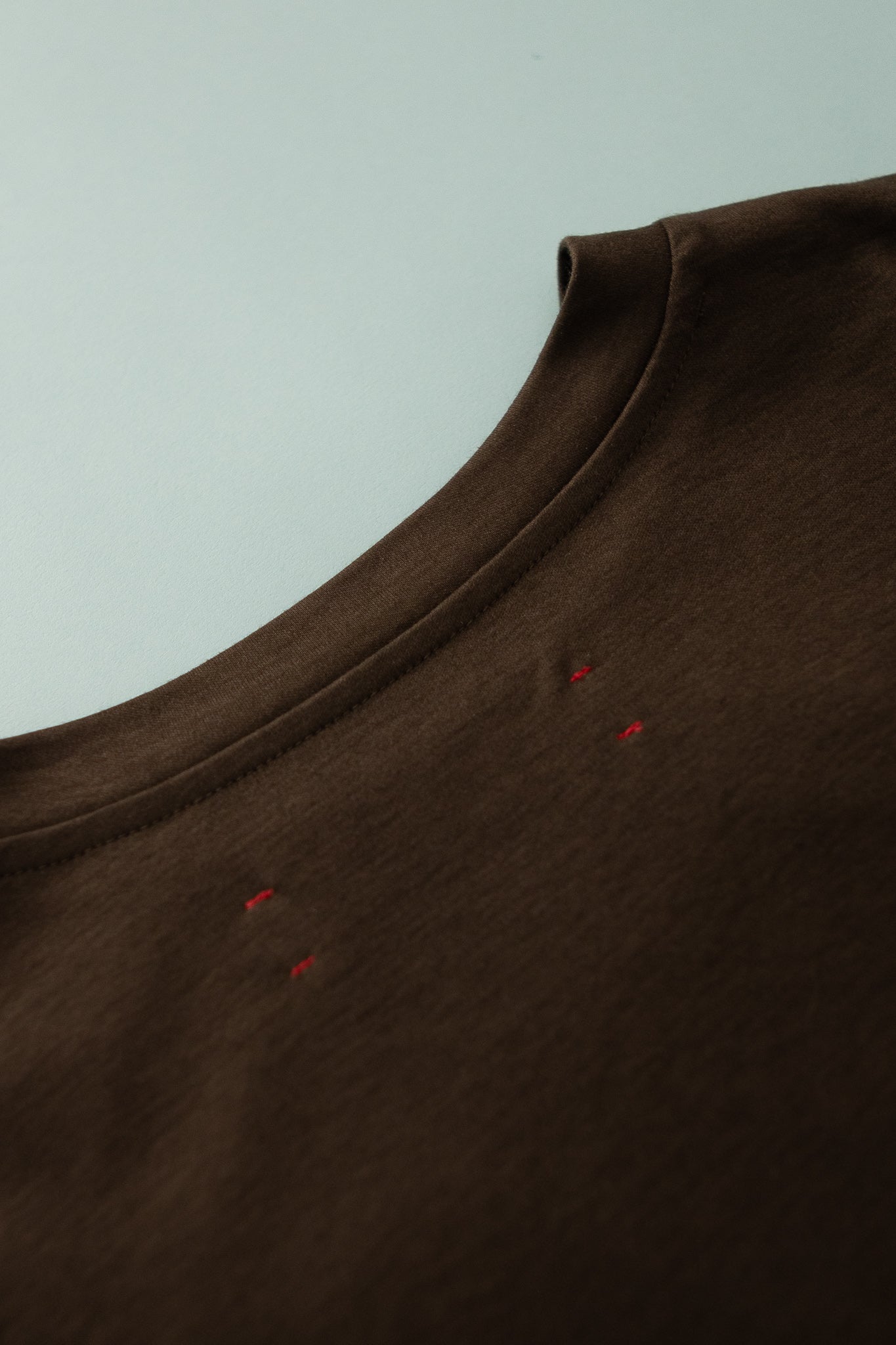 District Vision Dolman Mens Short Sleeve Tee in deep brown color showcasing the neckline and subtle design details.