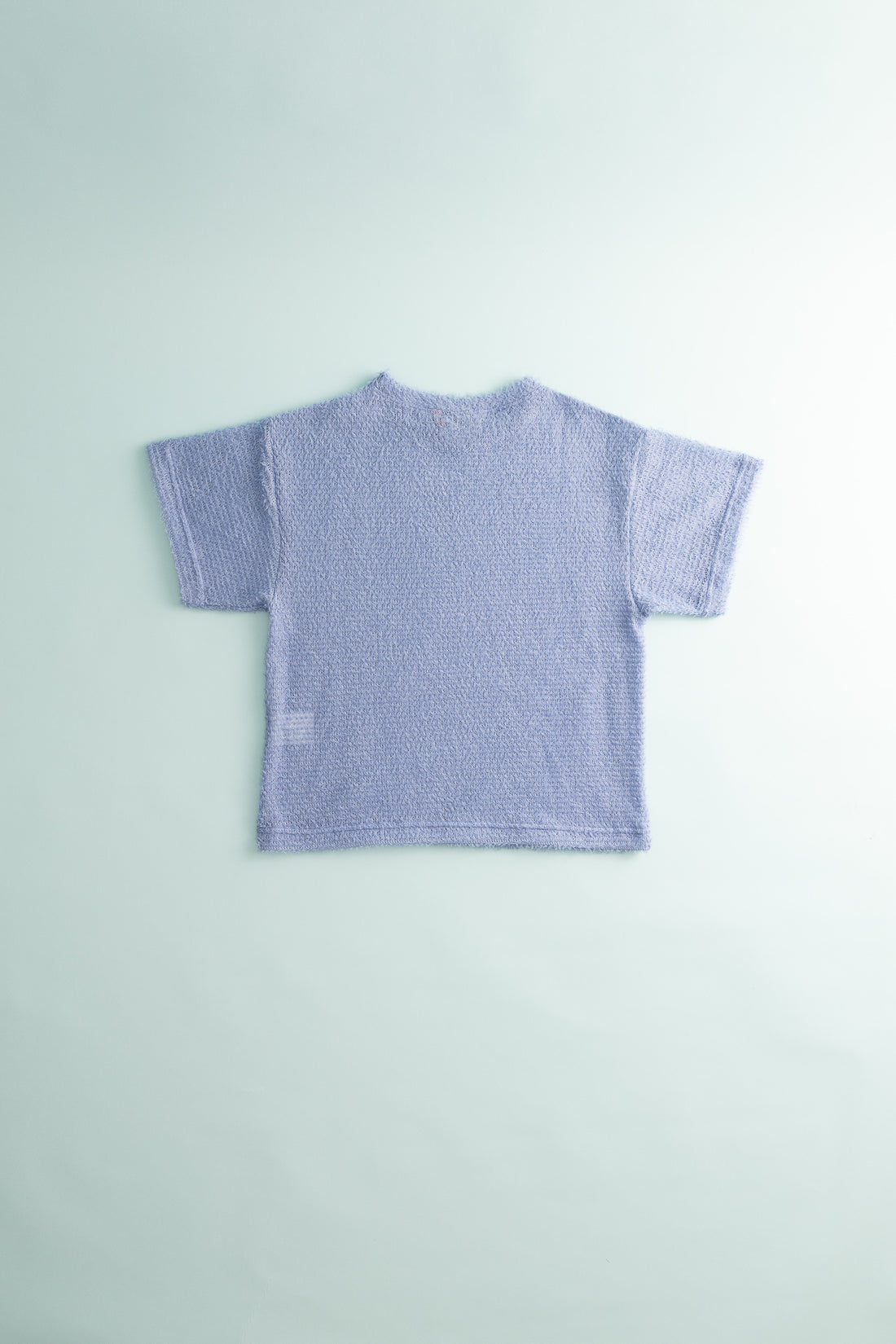 Back view of Shag Tee v2.0 in light purple color, showcasing its ultralight and compressible design.