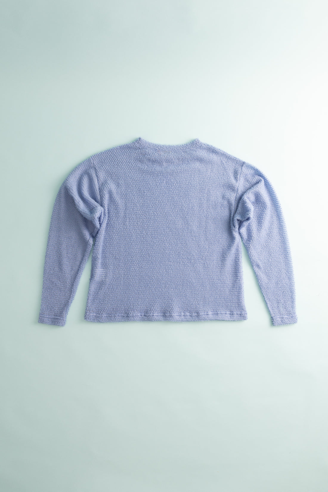 Back view of Shag Sweater v2.0 in lavender color, showcasing its lightweight and compressible design.