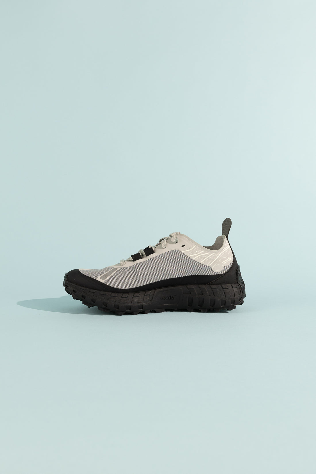 001A - Pewter side view showing the modern design and texture of the shoe on a soft blue background.