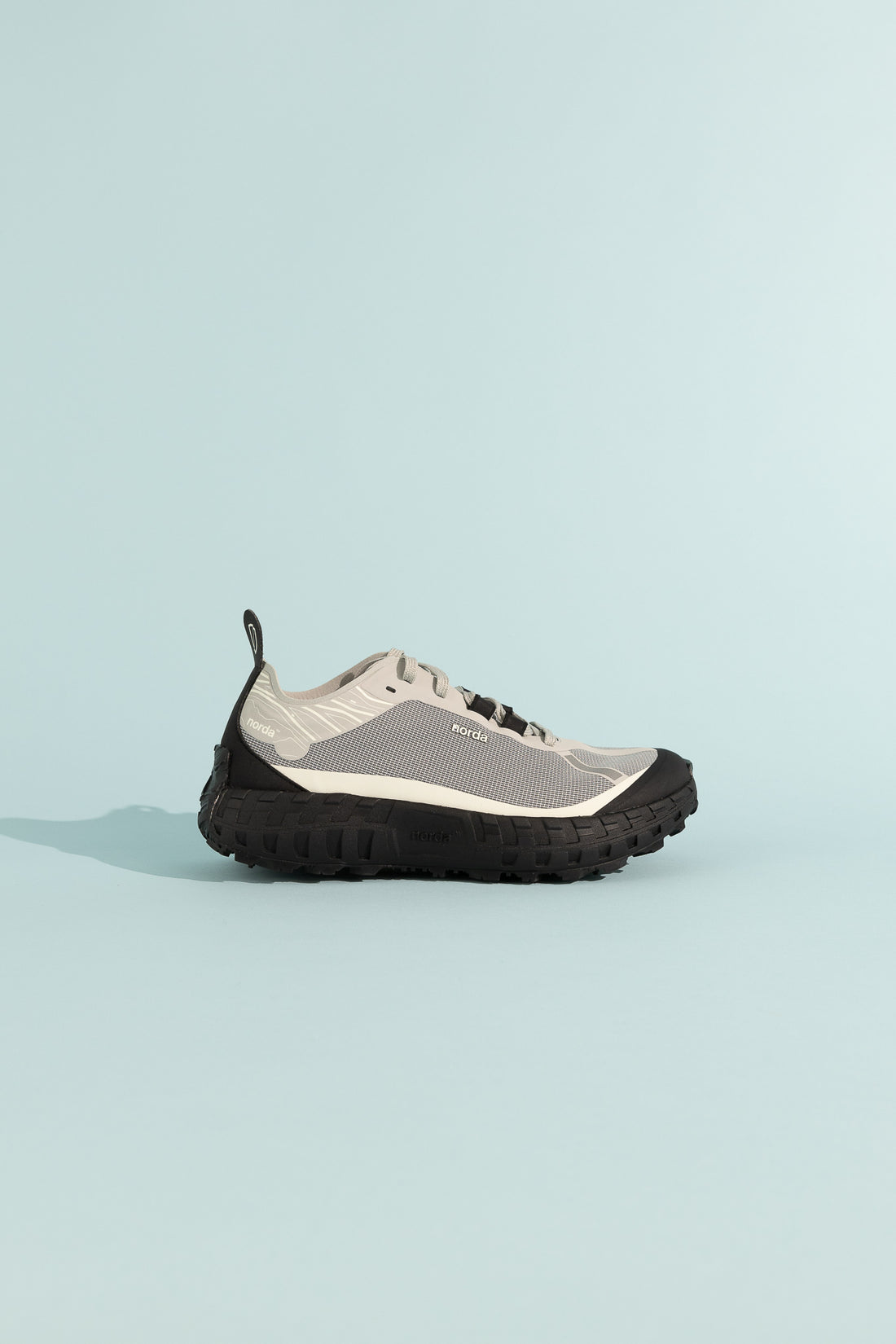 001A - Pewter stylish shoe in grey and black on a light blue background.