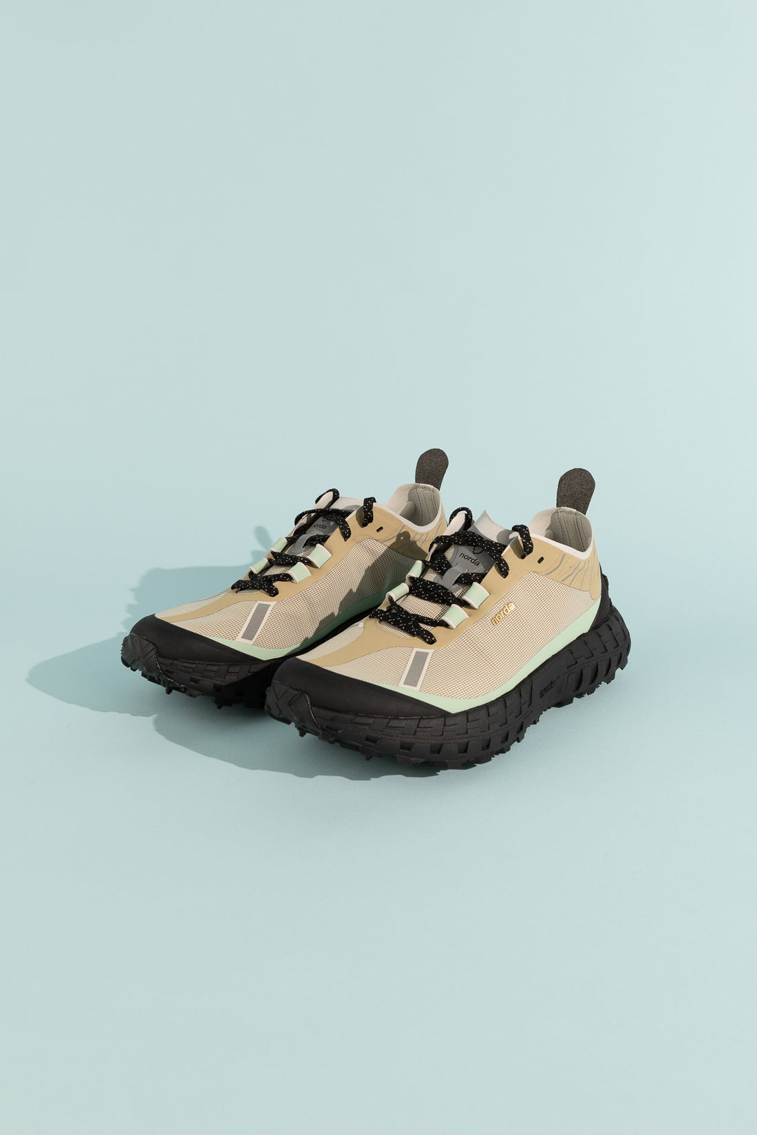Image of the 001A - Astral shoes featuring a black and beige design on a light blue background.