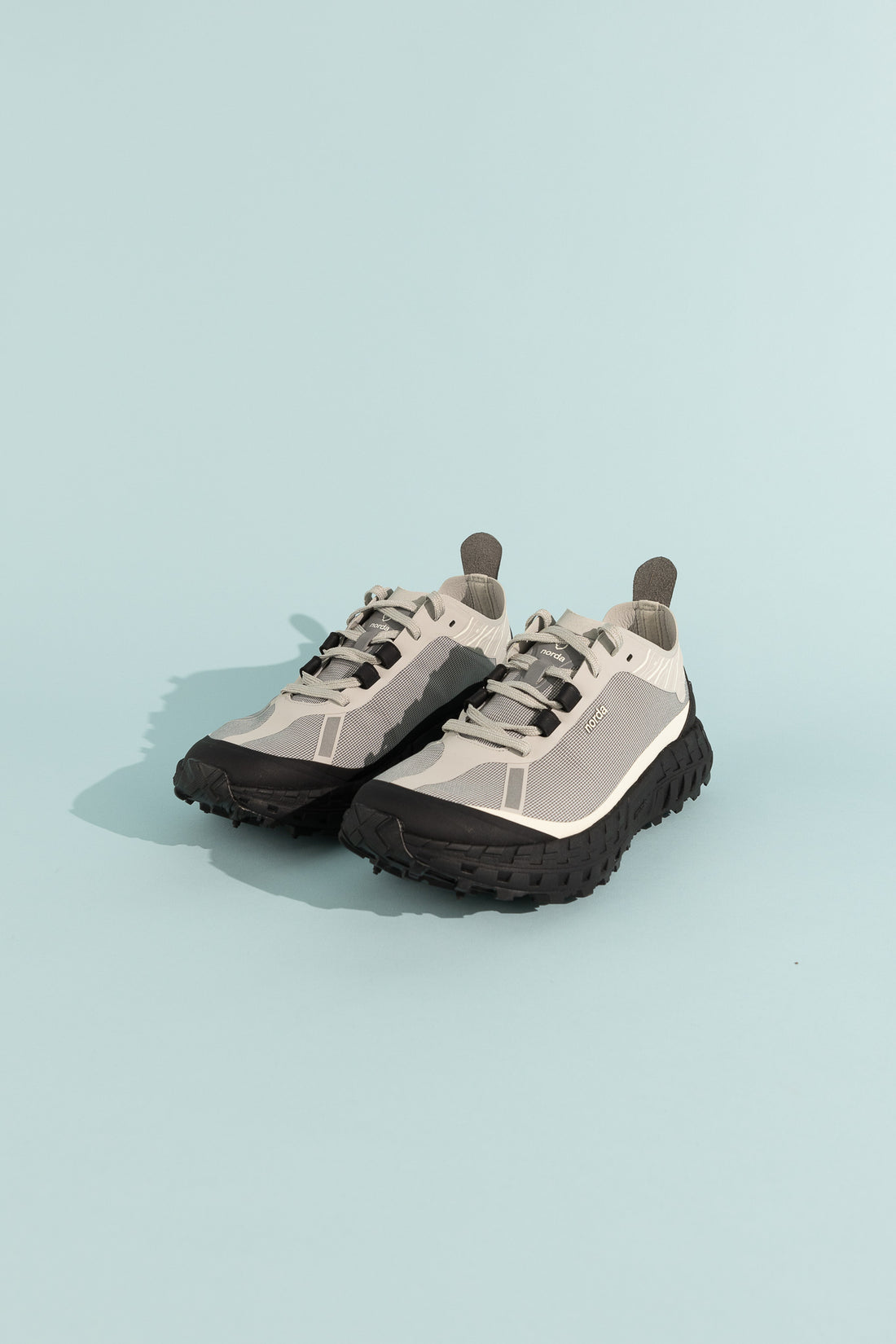 001A - Pewter shoes displayed on a light blue background showcasing unique design and features.