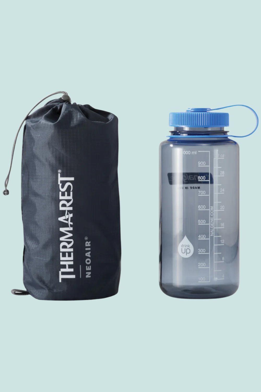 Thermarest NeoAir XLite NXT Sleeping Mat storage bag and water bottle on light background.